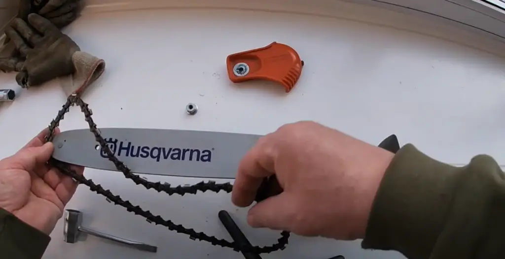 How do you adjust the chain on a Husqvarna chainsaw?
